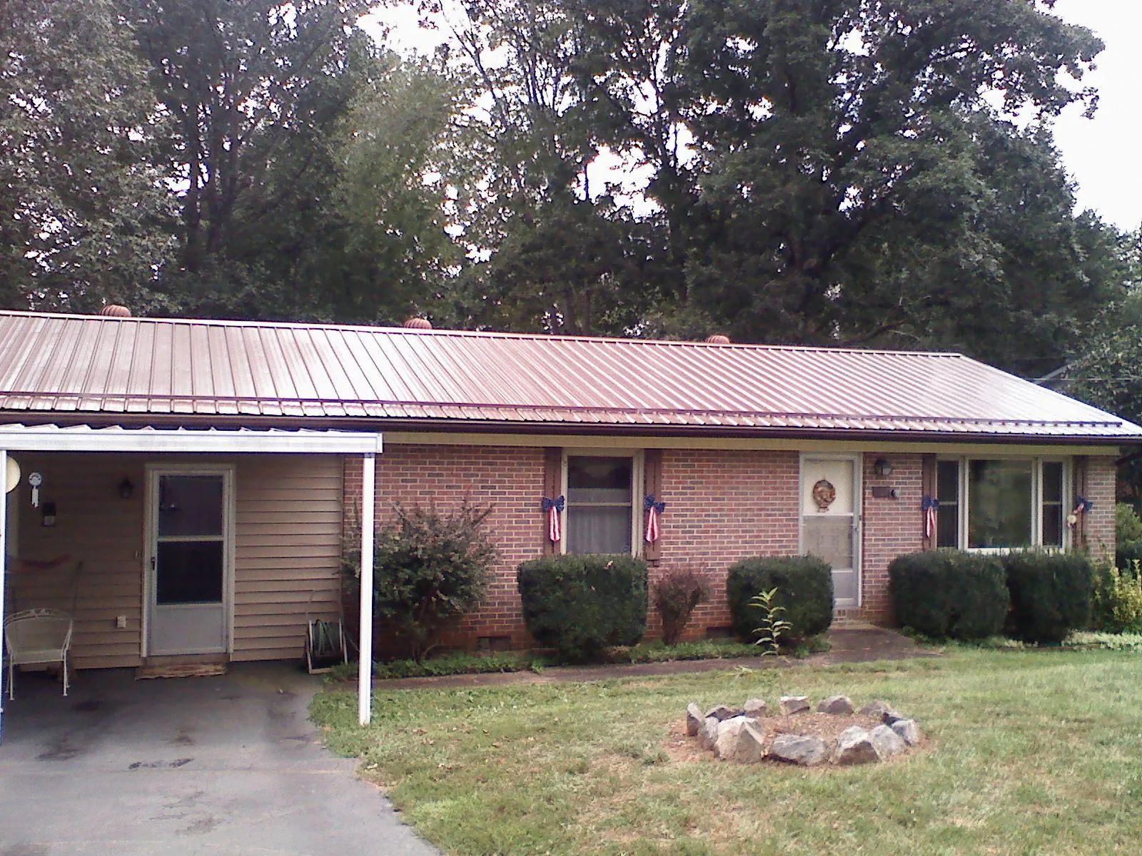 Bronze metal roof and carport on a brick ranch home — Roof Repair work by our crew in Little Rock