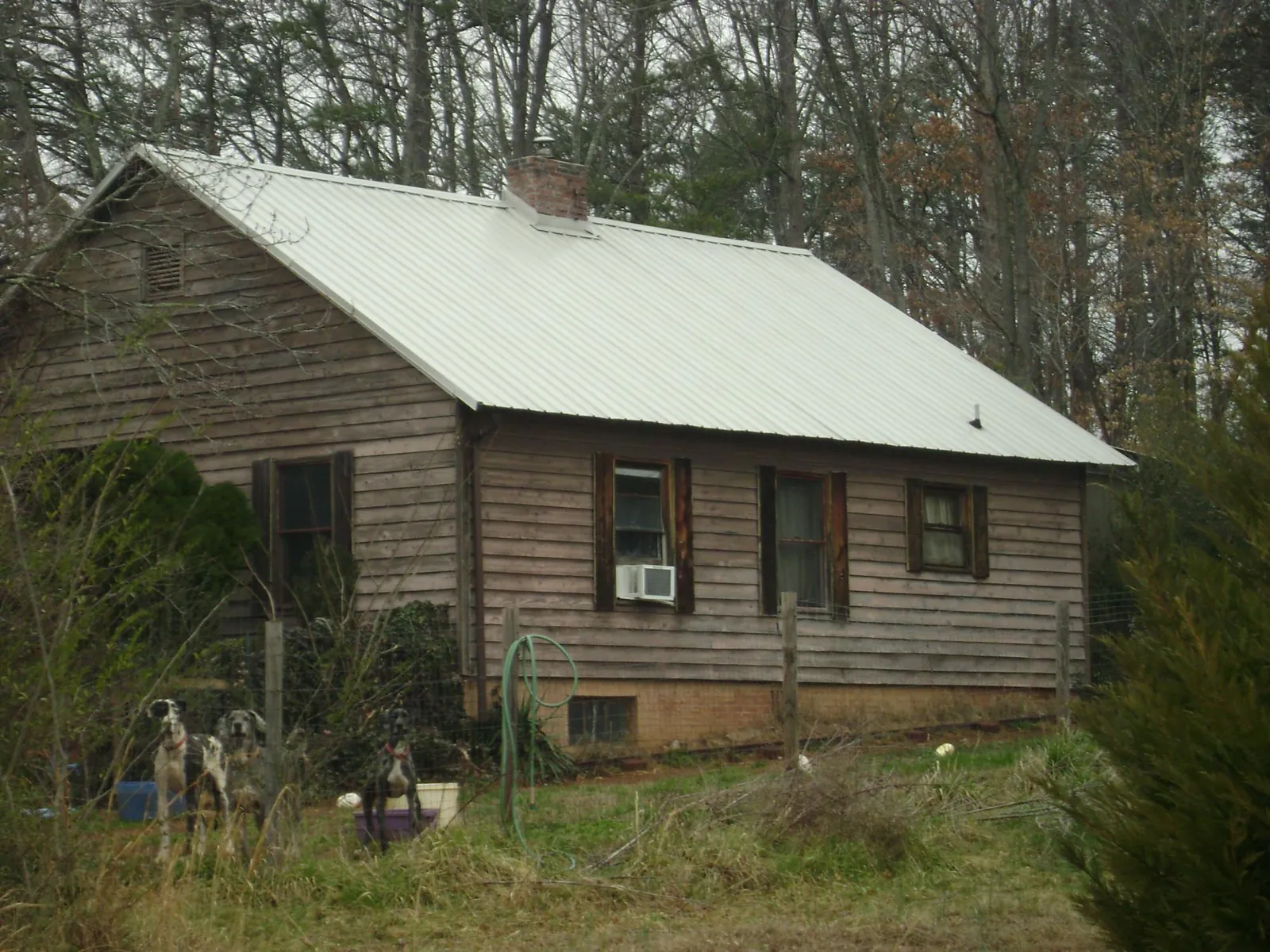 White metal roof on an old wood sided farmhouse, from a Metal Roof Installation job in Little Rock